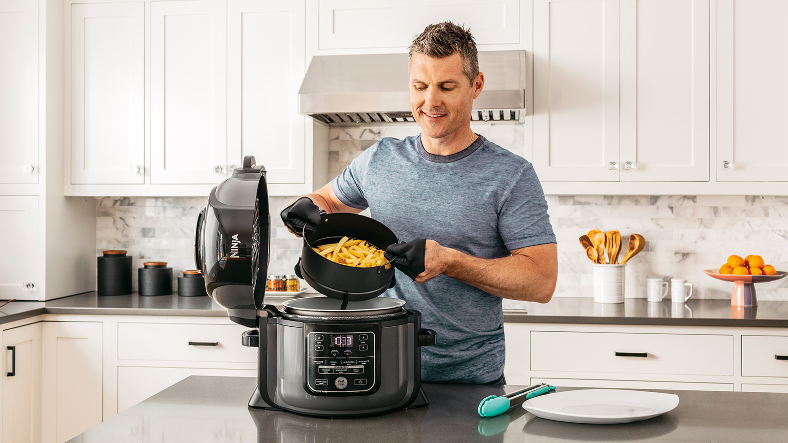 Hombre cocinando en una Olla eléctrica Ninja OP300EU